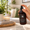AromaHoliday Glow Rhubarb & Black Plum room spray being sprayed in a luxury living room, creating a warm and inviting home fragrance experience.
